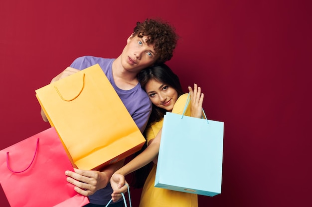 Young boy and girl colorful bags shopping fun isolated background unaltered