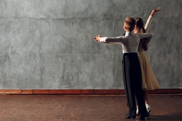 Young boy and girl dancing in ballroom dance Viennese Waltz.