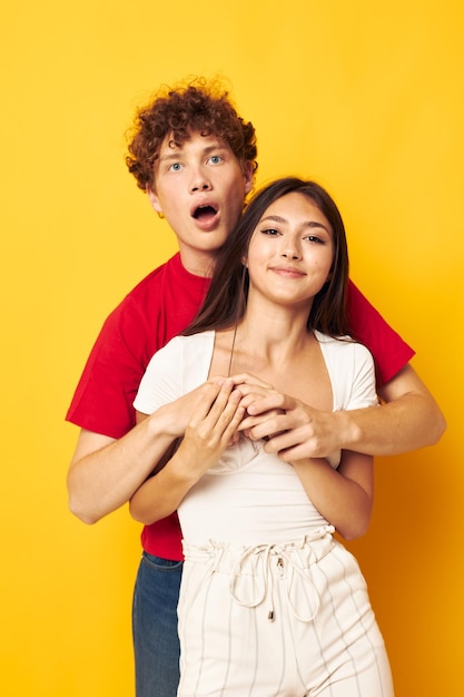 Young boy and girl Friendship posing hugs together yellow background unaltered