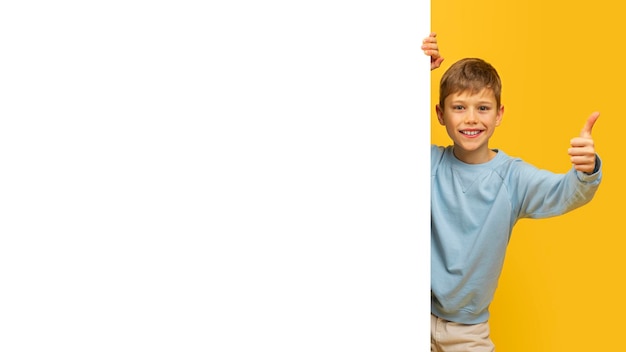 Young boy giving thumbs up with copy space