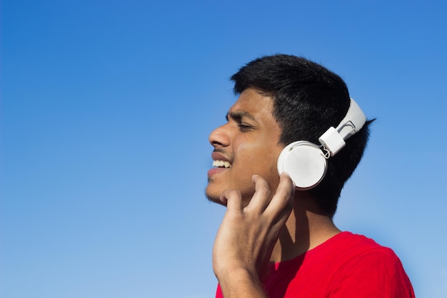 Young boy handsome teenager kid listening to music with headphones in relaxed mood emotions