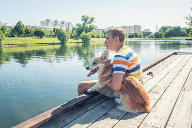 Young boy and his pet dog on a wooden peer