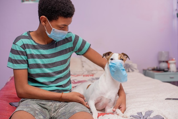 Young boy and his pet sitting on bed