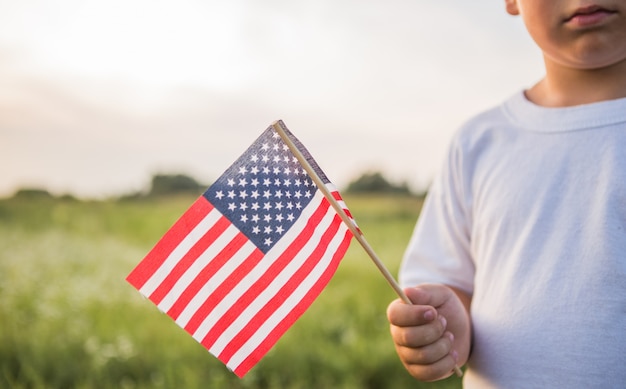 Young boy holding an American flag in his hand