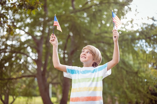 アメリカの旗を持っている若い少年