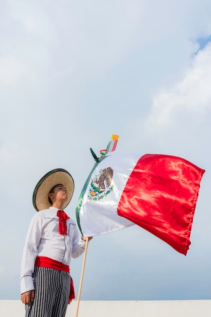 Photo young boy holding flag of mexico