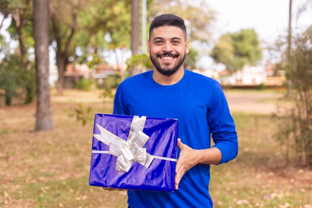 Young boy holding a gift in the park