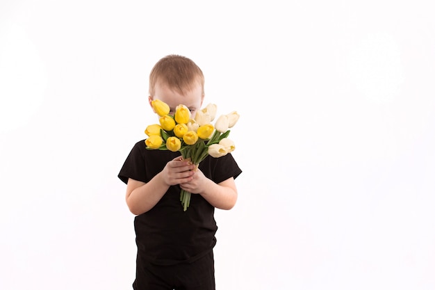 Young boy holding tulips isolated on white