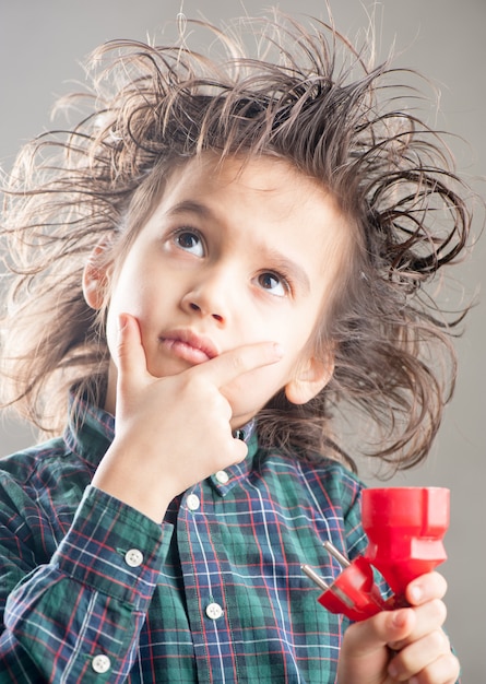 Young boy holding wire and connects it