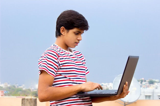 A young boy on home terrace with Laptop studing from home Online education concept