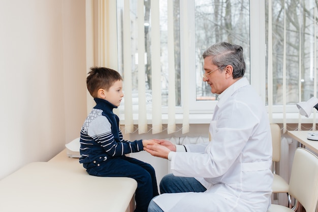 A young boy is listened to and treated by an experienced doctor in a modern clinic. A virus, and an epidemic