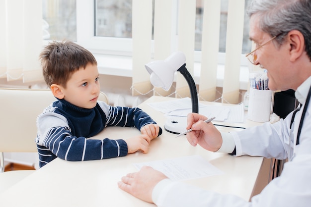 A young boy is listened to and treated by an experienced doctor in a modern clinic. A virus, and an epidemic