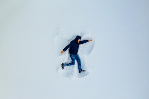 Young boy is making figure in snow winter vocations making fun
in snow