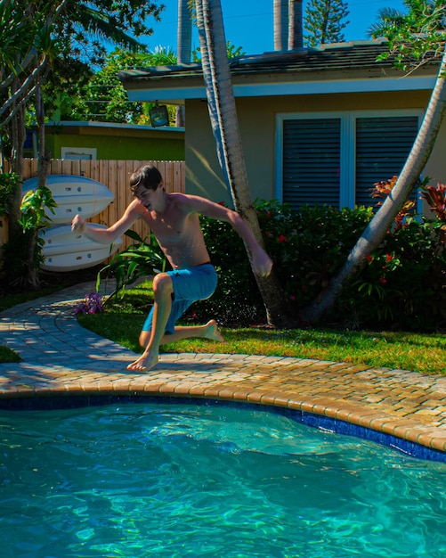 Photo young boy jumping in swimming pool
