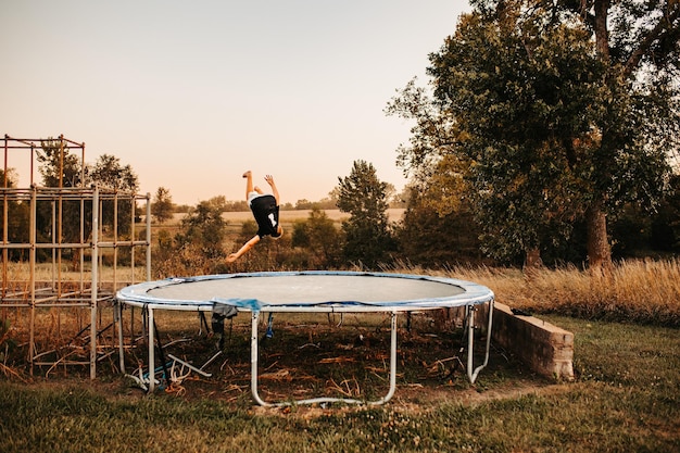 Photo young boy jumping on a trampoline