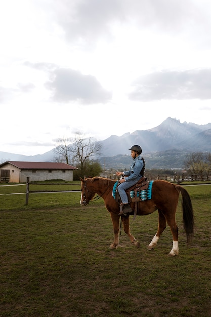 Photo young boy learning how to ride horse