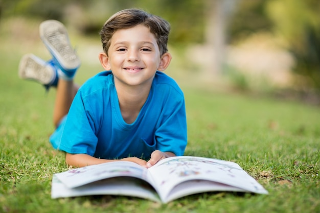 本と草の上に横たわる少年