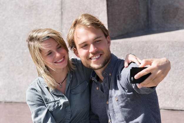 Young boy making selfie with his girlfriend as friendship and togetherness concept