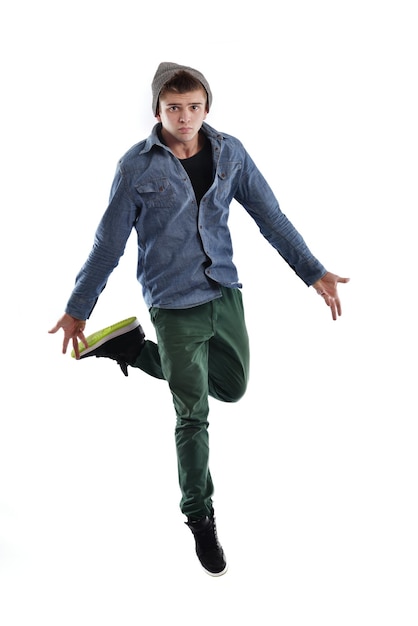 Giovane ragazzo uomo adolescente ballare e saltare isolato su sfondo bianco in studio