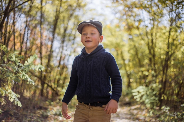 Giovane ragazzo gioca con airplaine giocattolo nelle mani. happy kid sta giocando nel parco all'aperto