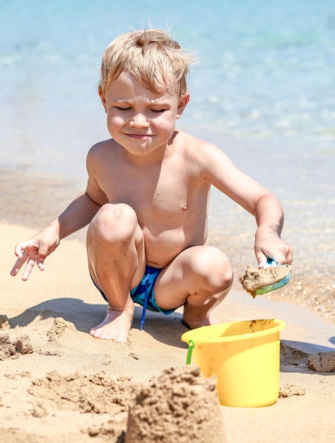 砂浜で遊んでいる少年とビーチで波