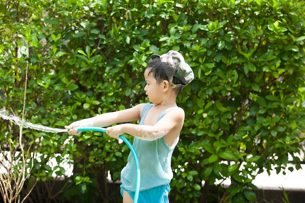 Young boy playing with a hose