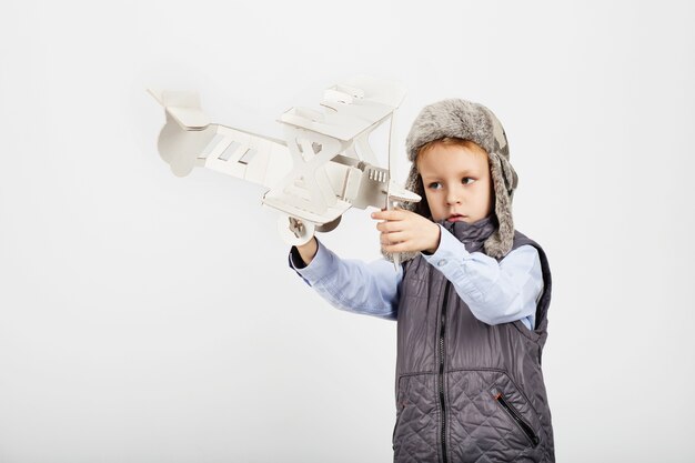 Young boy playing with a paper toy airplane