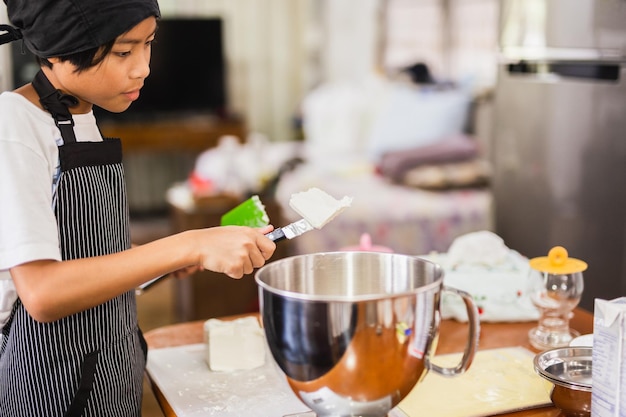 Young boy preparing ingredient for baking cake in kitchen