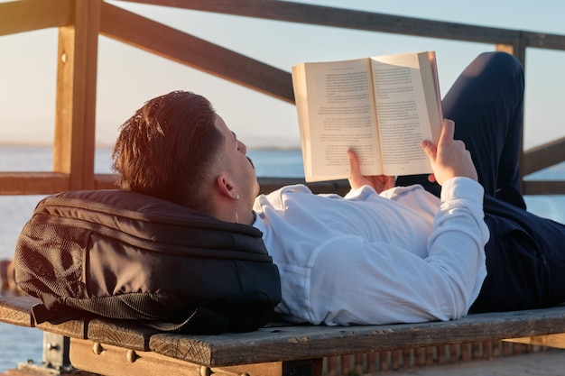 Young boy reading a book in the sunlight