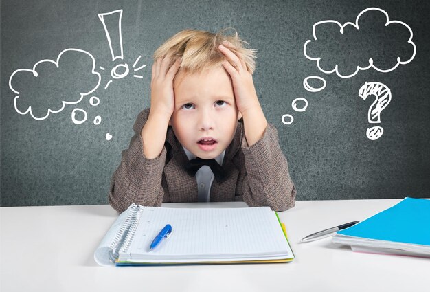 Young boy reading book with signs on background