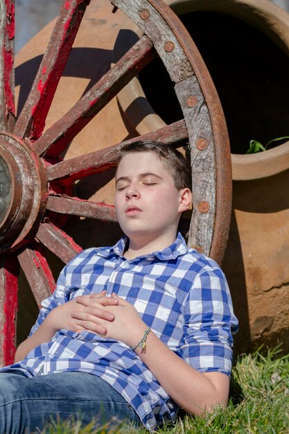 Foto ragazzo che legge un libro nel bosco con profondità di campo ridotta e spazio di copia