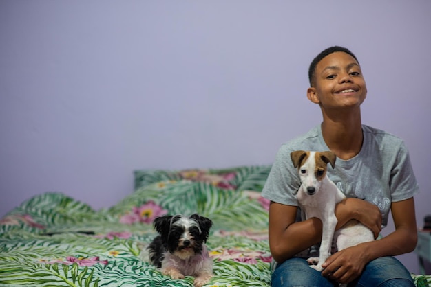 Young boy sitting on bed with his pets