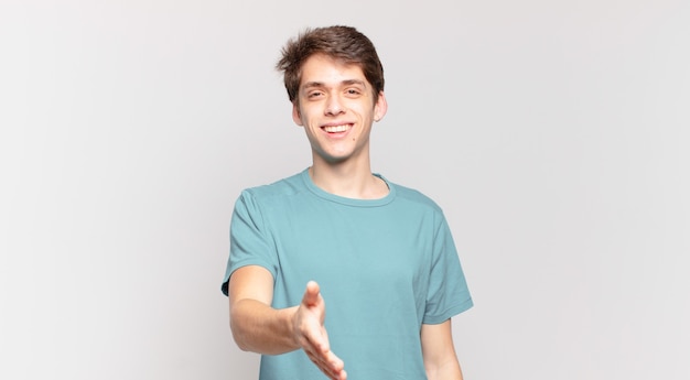 Young boy smiling, looking happy, confident and friendly, offering a handshake to close a deal, cooperating