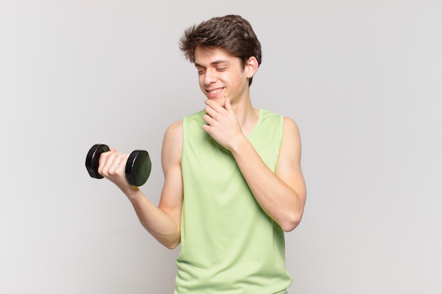 Ragazzo sorridente con un'espressione felice e sicura con la mano sul mento, chiedendosi e guardando di lato. concetto di manubrio