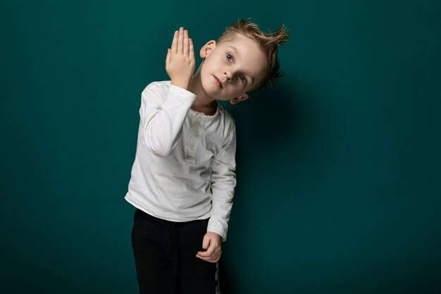 Young boy standing in front of green wall