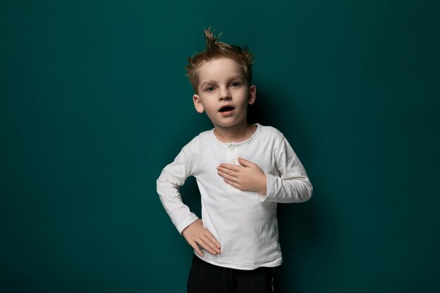 Young boy standing in front of green wall