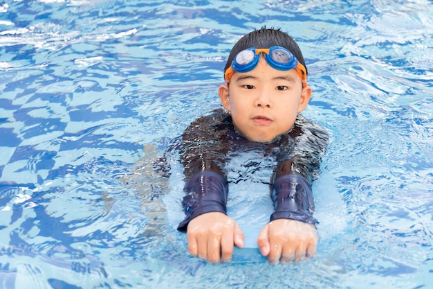 Young boy swimming in pool.