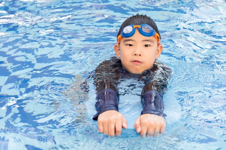 Photo プールで泳いでいる少年。