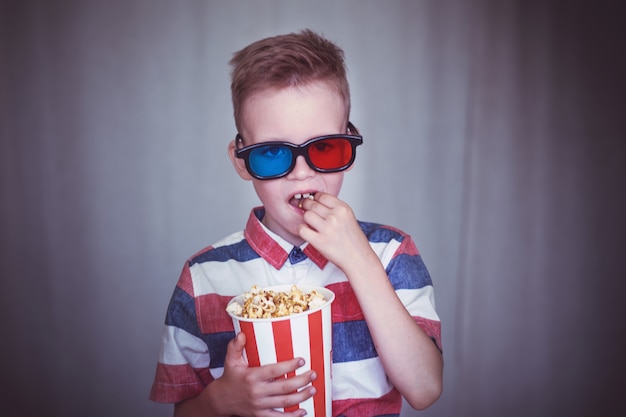 Giovane ragazzo guarda un film con gli occhiali 3d al cinema oa casa