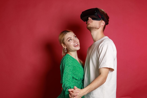 Young boy wearing VR glasses and Dancing with his girlfriend on the red background
