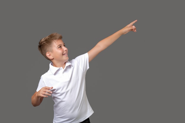 Young boy wearing white tee shirt pointing away
