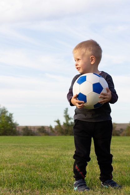 Photo young boy with ball soccer player smiling