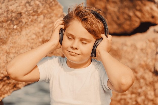 Young boy with headphones listening to music outdoors