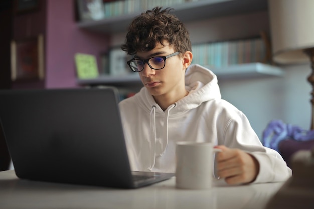 Фото Молодой мальчик работает на компьютере дома