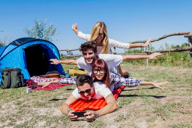 Photo young boys and girls in campsite piled up smiling