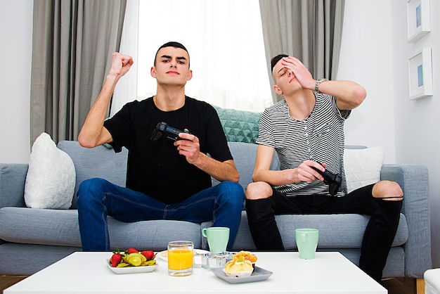 young boys playing video game at home