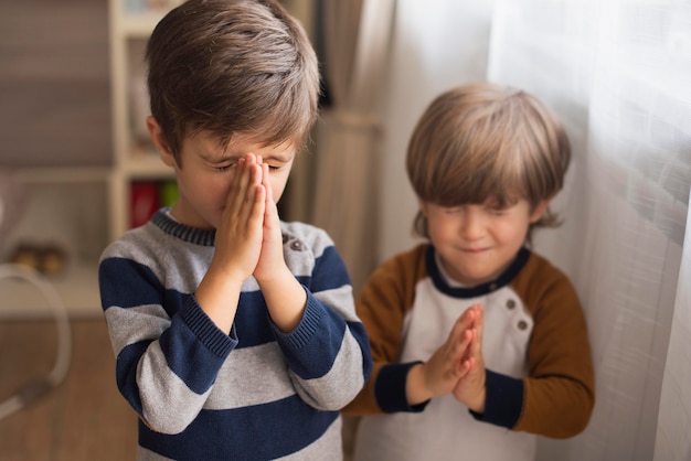 自宅で一緒に祈る少年