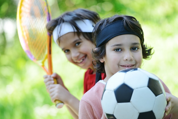 Giovani ragazzi con calcio e tennis fuori