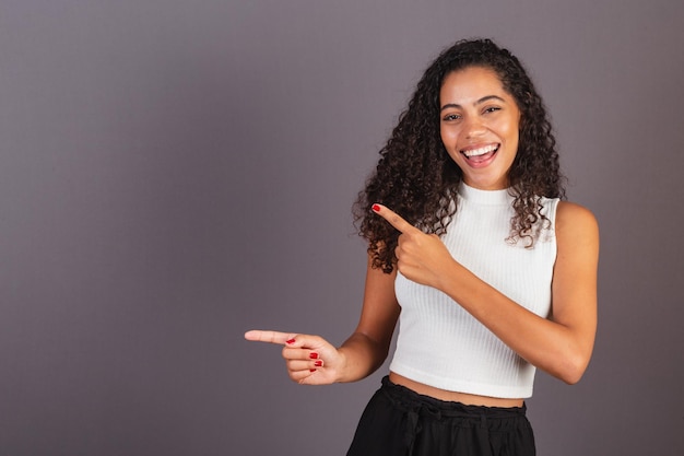 左の宣伝写真を指している若いブラジル人黒人女性