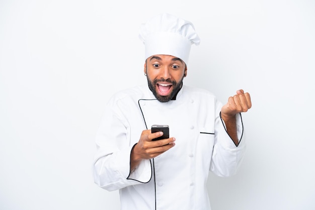 Young Brazilian chef man isolated on white background surprised and sending a message